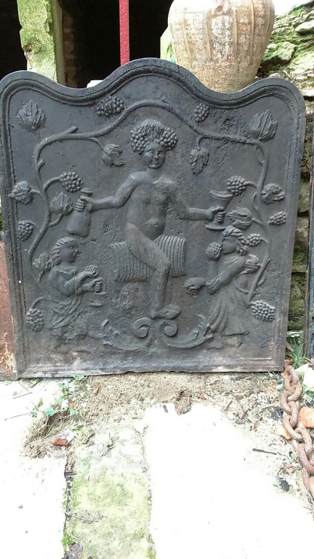 Plaque de cheminée en fonte  Bacchus assis sur un tonneau avec bouteille en main, entouré de vignes. (64x64 cm) € 250 